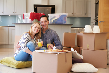 New home buyers eating pizza next to moving boxes