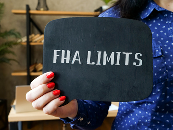Woman holding a FHA limits sign 